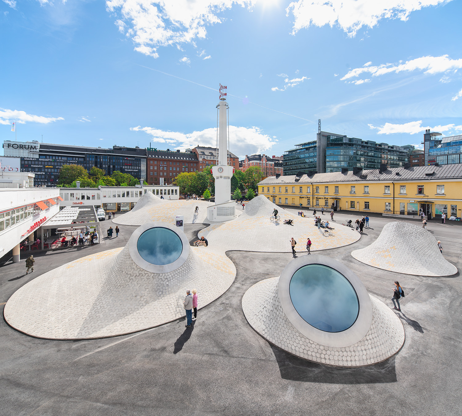 People on a terrace, skating and cycling in an urban setting.