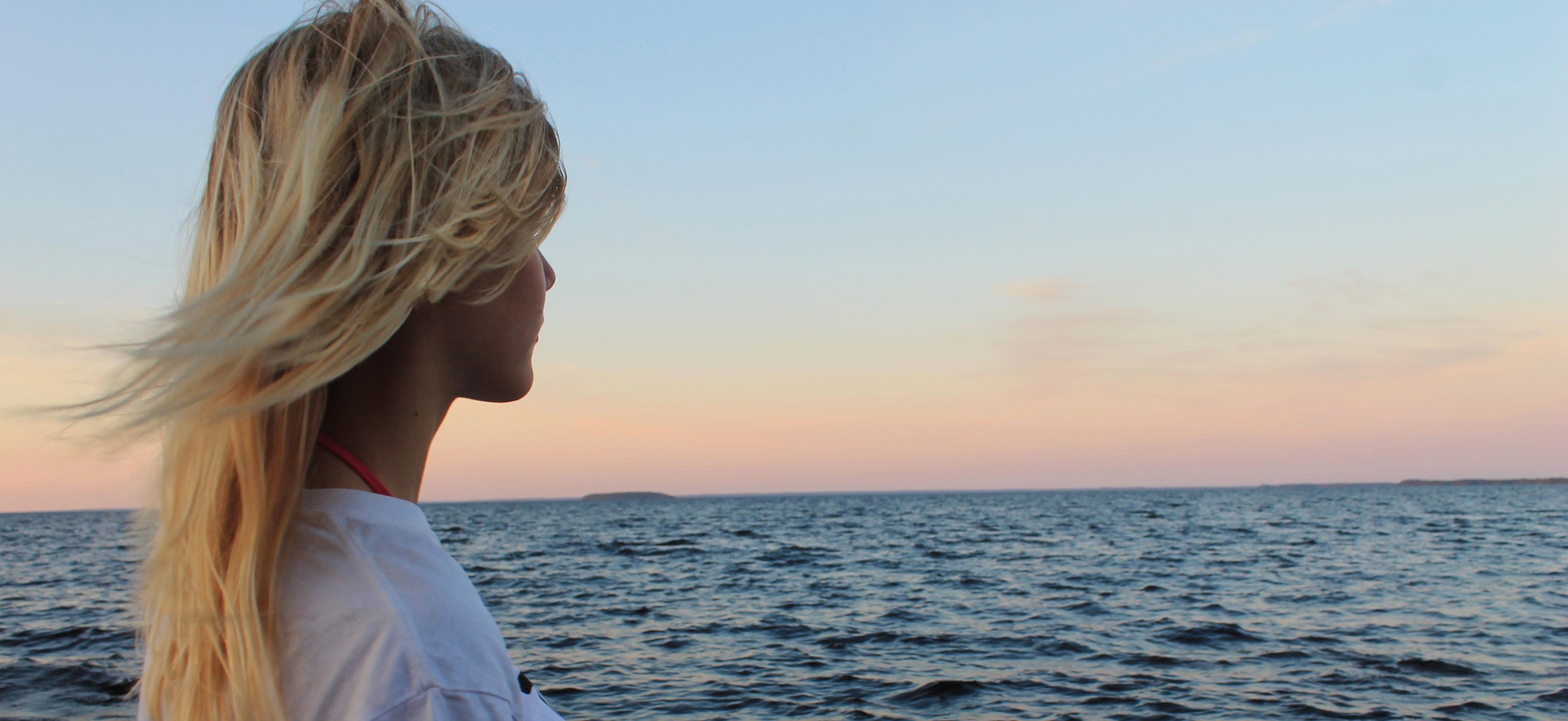 A woman staring at the lake Oulujärvi in Finland.